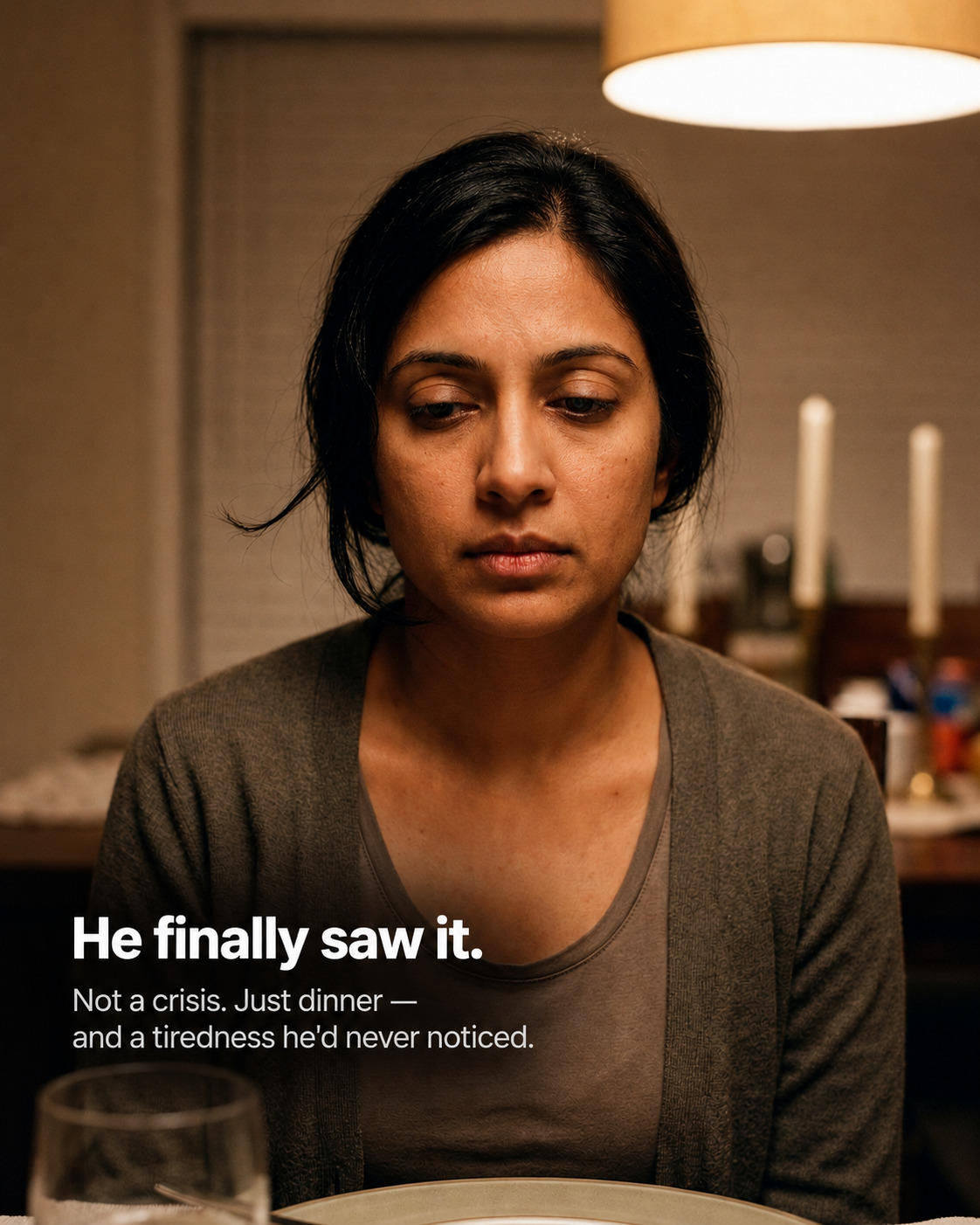 A woman's unguarded face at dinner, eyes cast down, carrying a quiet tiredness her partner had never noticed before